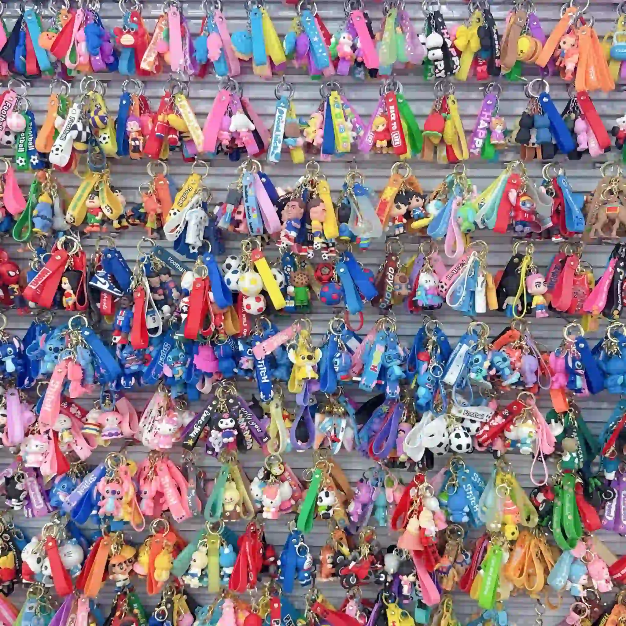 Large collection of colorful cartoon PVC keychains with matching straps